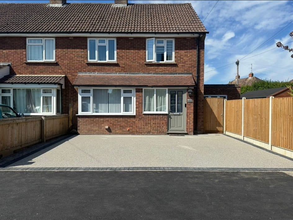 Completed buff resin-bound driveway with block border at a red-brick house