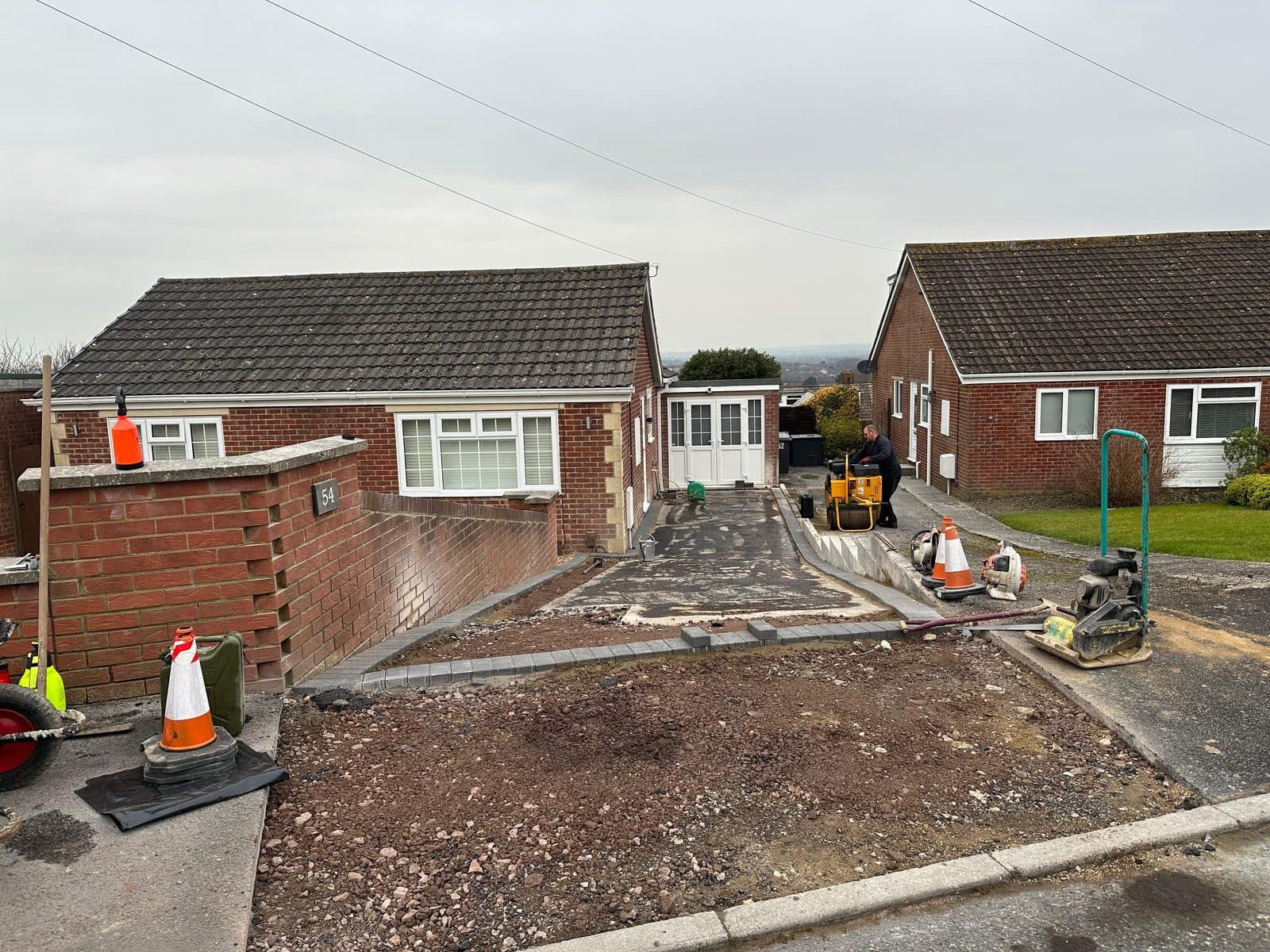 Bungalow driveway being compacted with a roller during construction