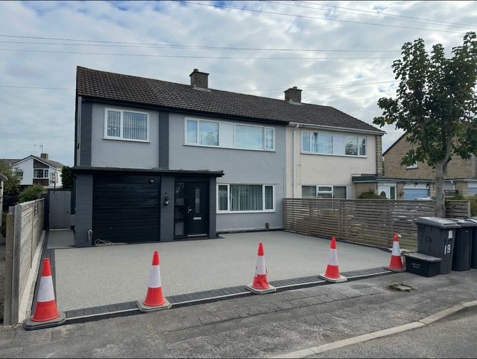 Finished light-grey resin-bound driveway at a rendered semi-detached house
